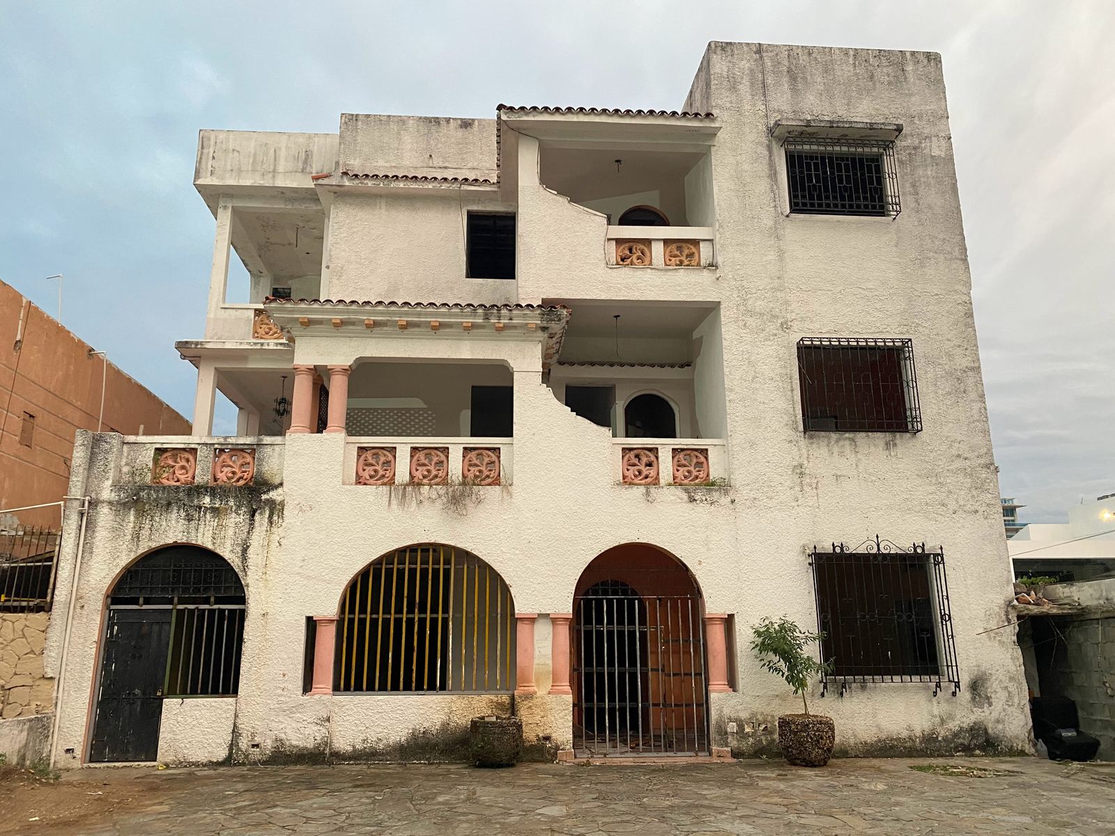 Casa de tres niveles con balcones y arcos en una calle de Santo Domingo